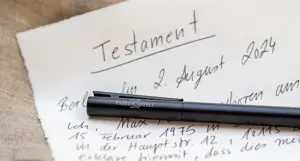 Auf einem Blatt Papier mit einem handschriftlich verfassten Testament liegt ein hochwertiger, schwarzer Kugelschreiber von Faber-Castell. Foto: Johanna Rundel